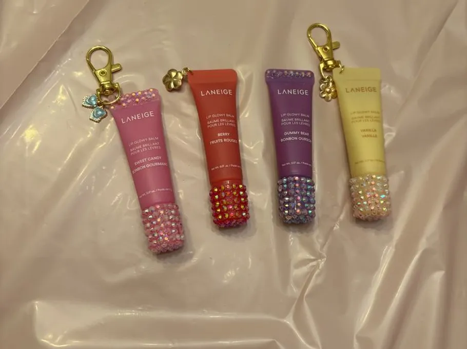 Vier Lippenbalsame mit Juwelenkappen auf Plastik.