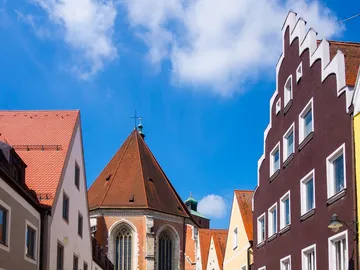 Historische Gebäude mit roten Dächern unter blauem Himmel.