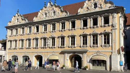 Baroque building with pedestrians in sunny square.