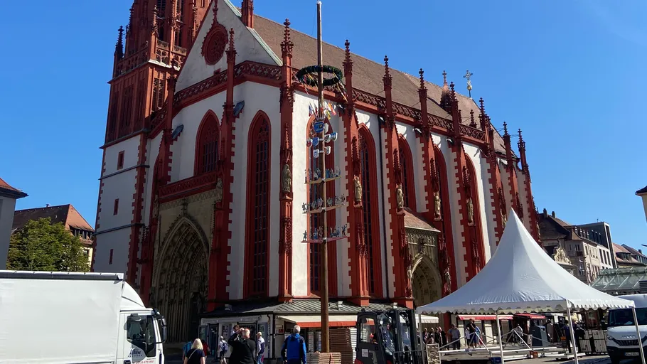 Gotische Kirche mit Menschen und Marktzelten.