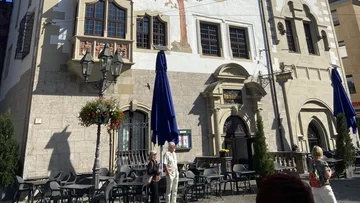 Historisches Gebäude mit Außenbestuhlung.