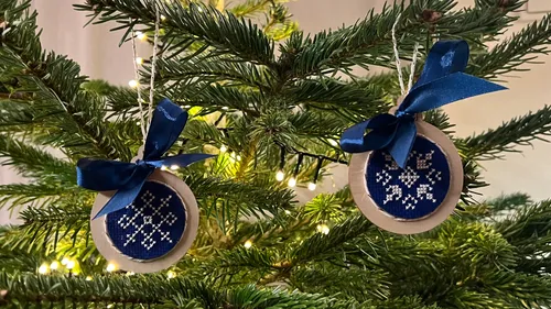 Christmas tree with blue embroidered ornaments.