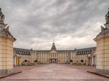 Barockschloss steht majestätisch unter einem bewölkten Himmel.