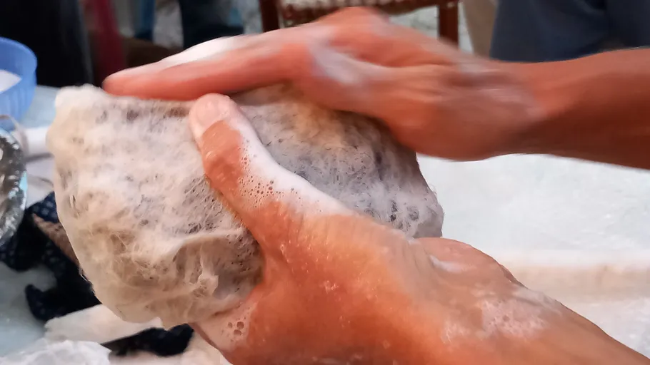 Hände waschen ein Tuch mit Seifenschaum.