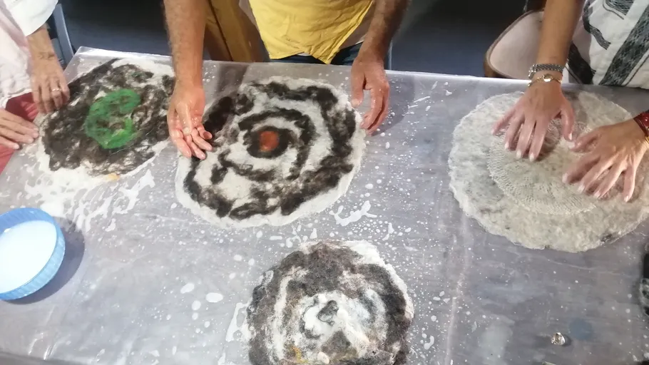 People crafting felt on table.