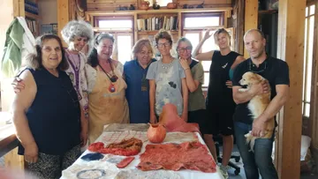 Gruppe posiert mit Kunsthandwerk auf Tisch drinnen.