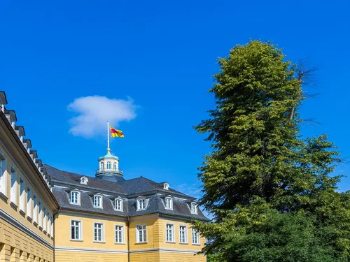 A building with a flag is under a blue sky.