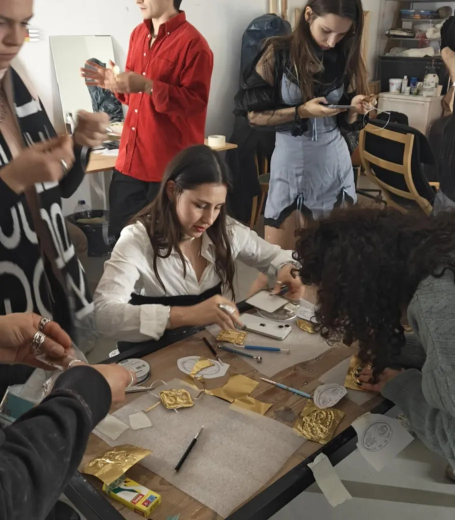 People crafting at a table, using tools.