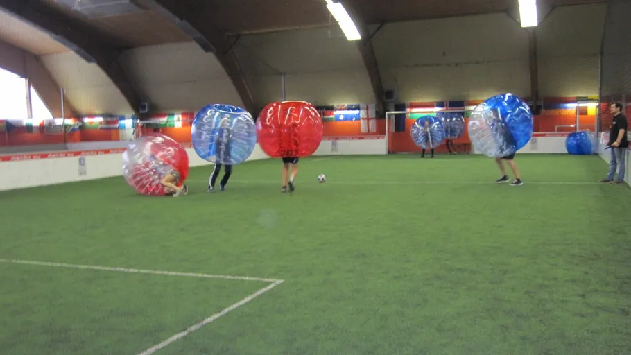 People playing bubble soccer indoors.