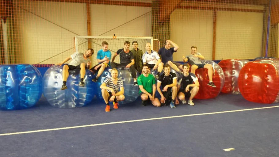 Group of people posing with bubble balls indoors.