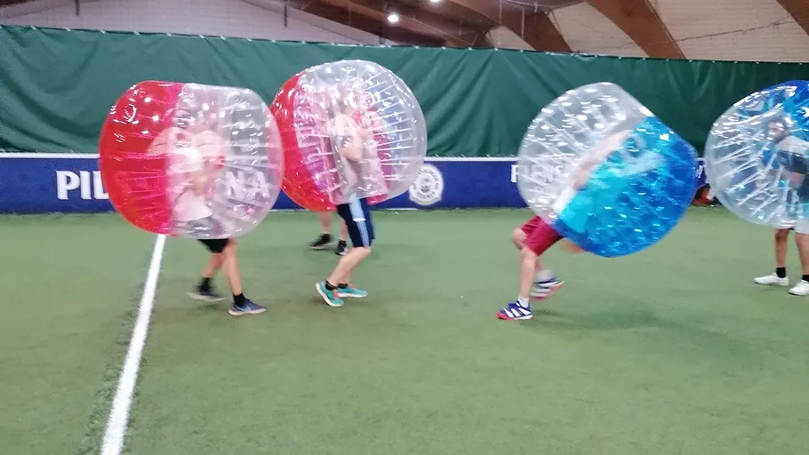 People playing bubble soccer indoors.