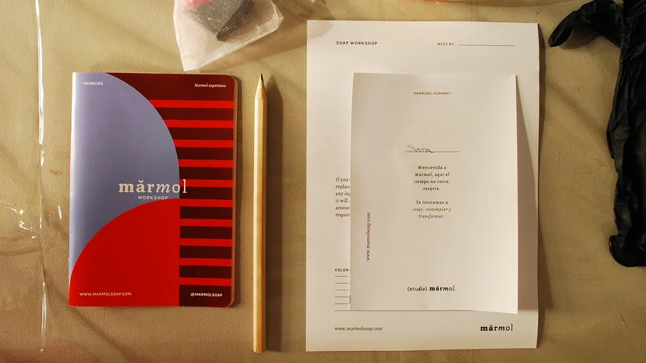 Notizbuch, Bleistift, Papiere auf beiger Oberfläche.