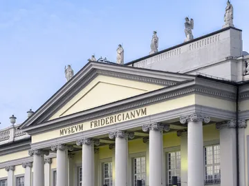 Museum zeigt neoklassizistische Architektur mit Statuen oben.