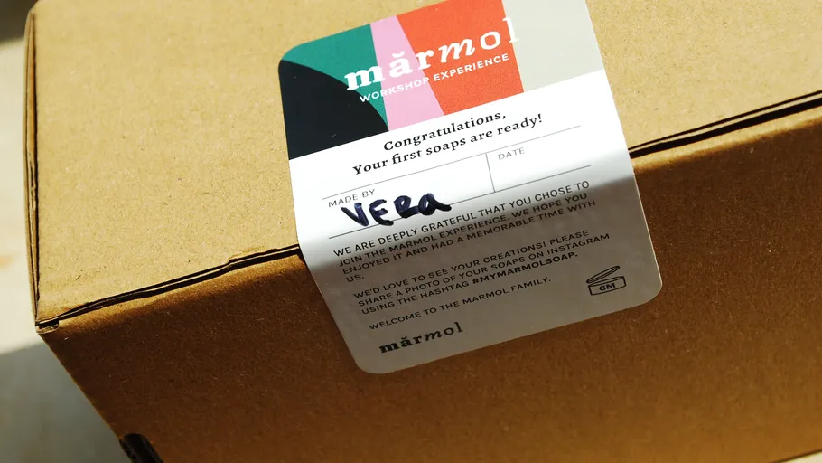 Karton mit buntem Etikett für Seifenworkshop.