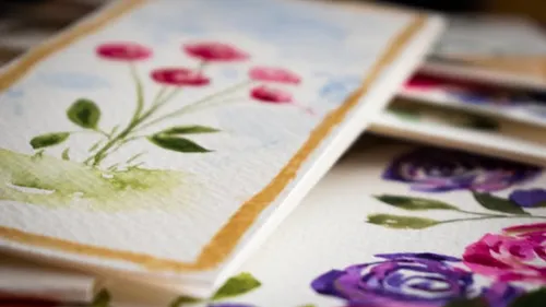 Watercolor floral paintings on paper, stacked.