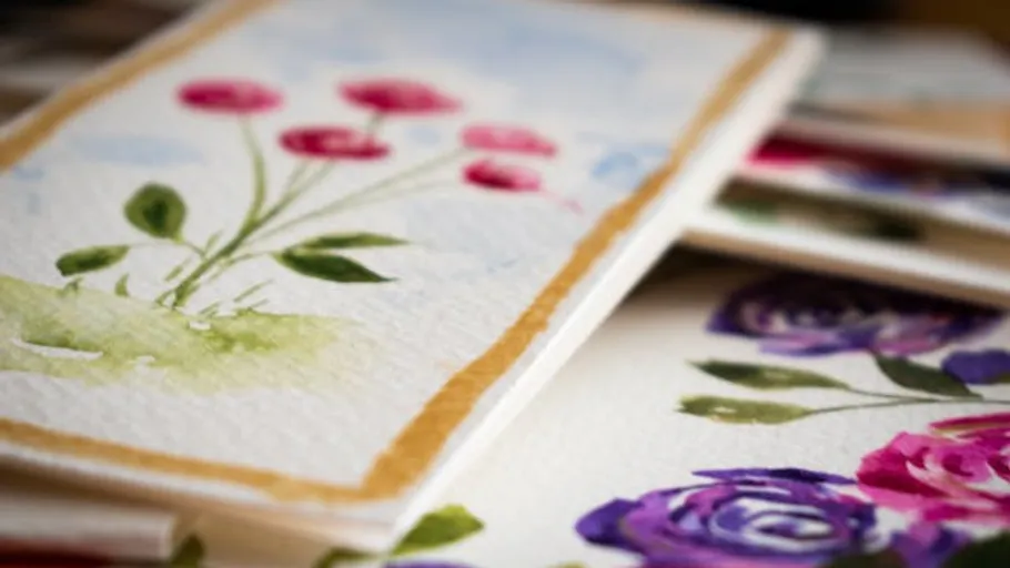 Watercolor floral paintings on paper, stacked.