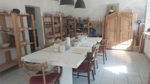 Pottery studio with worktable and shelves.