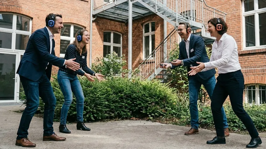 Group wearing headphones playing game outside.