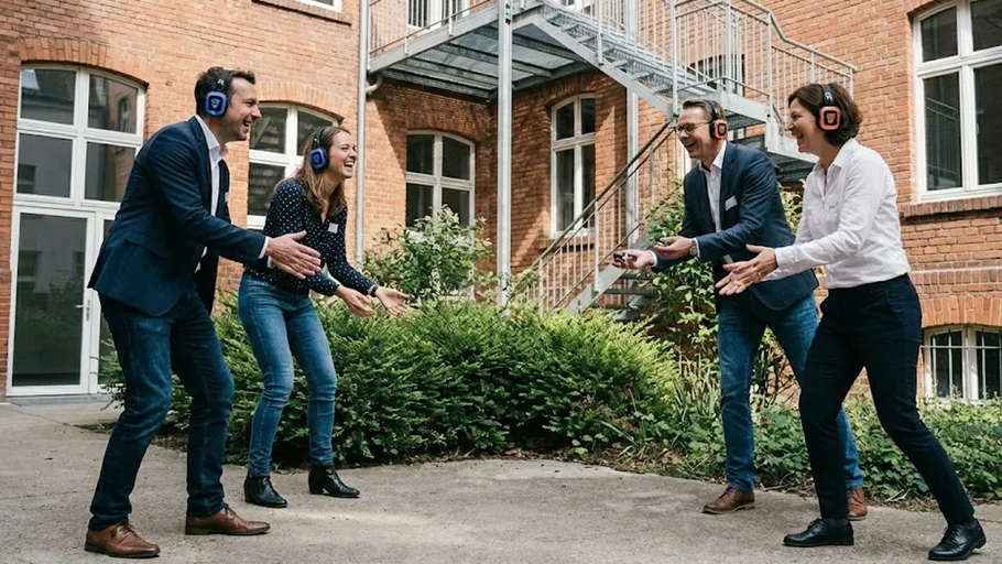 Two men and two women wearing headphones outside.