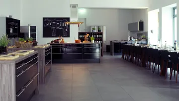 Modern kitchen with dining area, well-lit space.