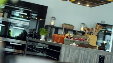 Modern kitchen with utensils and vegetables.