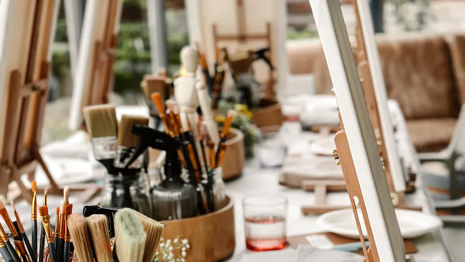 Paintbrushes and easels on indoor table.