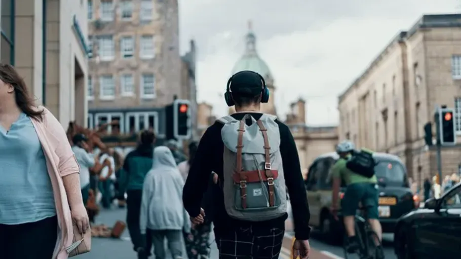 Person with backpack walking in busy city street.