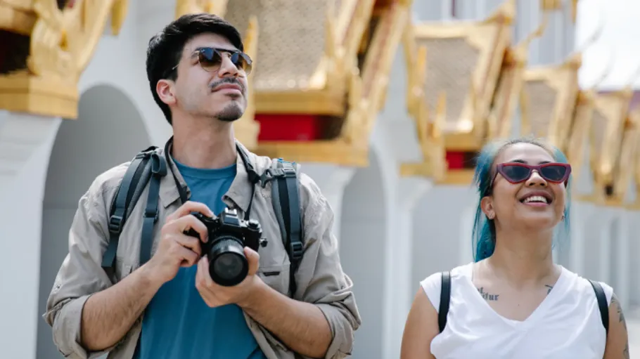 Tourists with camera enjoying temple architecture.