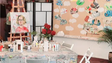Art studio with paintings and art supplies.