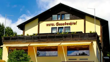 Gelbes Hotelgebäude mit braunen Akzenten.