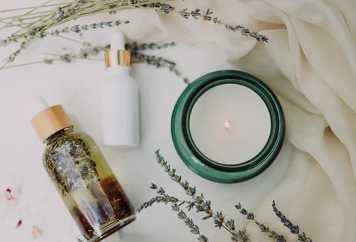 Aromatherapie-Setup mit Kerze und Ölflaschen.