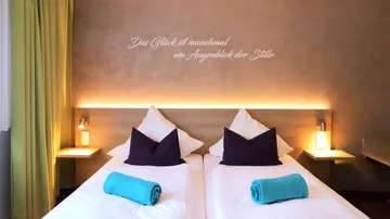 Two beds with pillows in a hotel room.