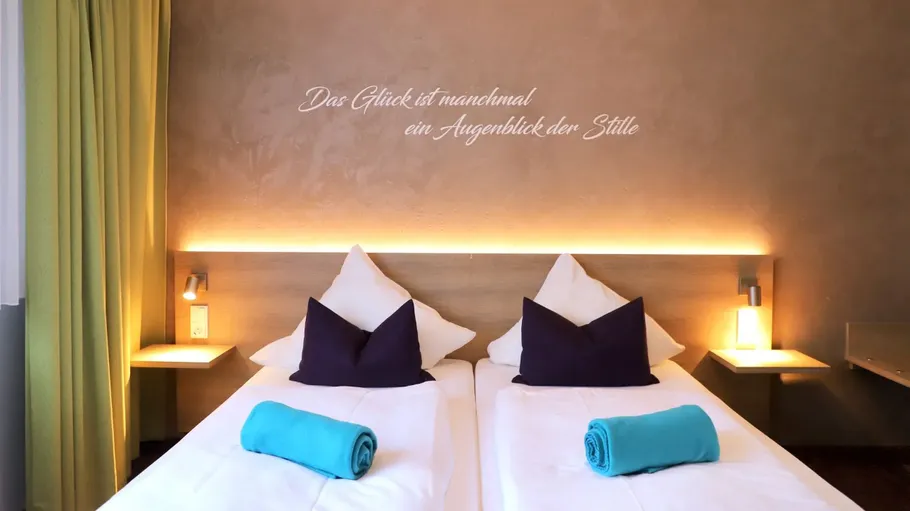 Two beds with pillows in a hotel room.