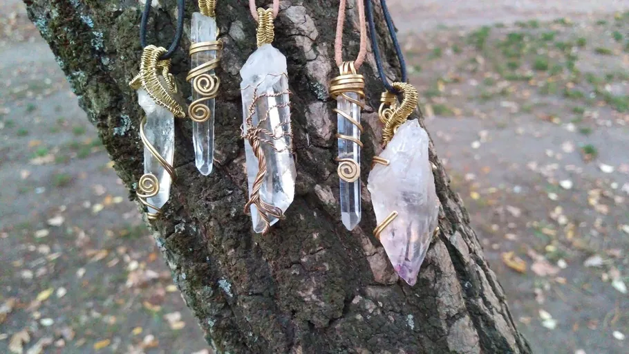 Crystal pendants hanging on tree outdoors.