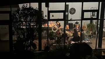Personen essen drinnen durch Fenster gesehen.