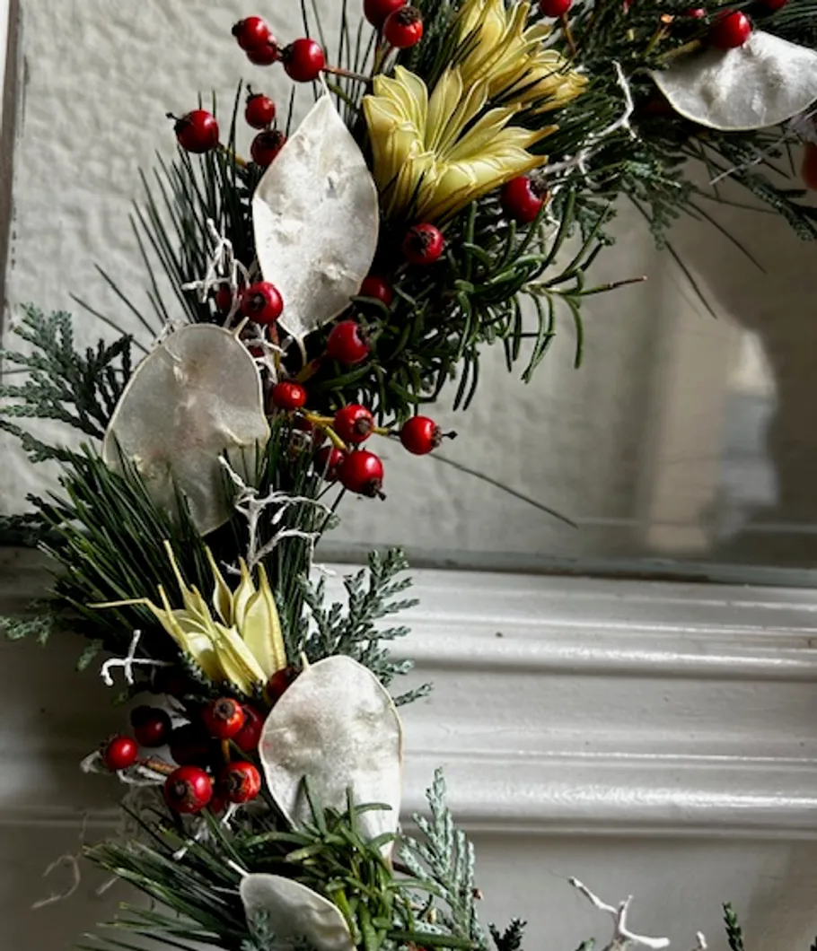 Festive wreath with red berries on mantel.