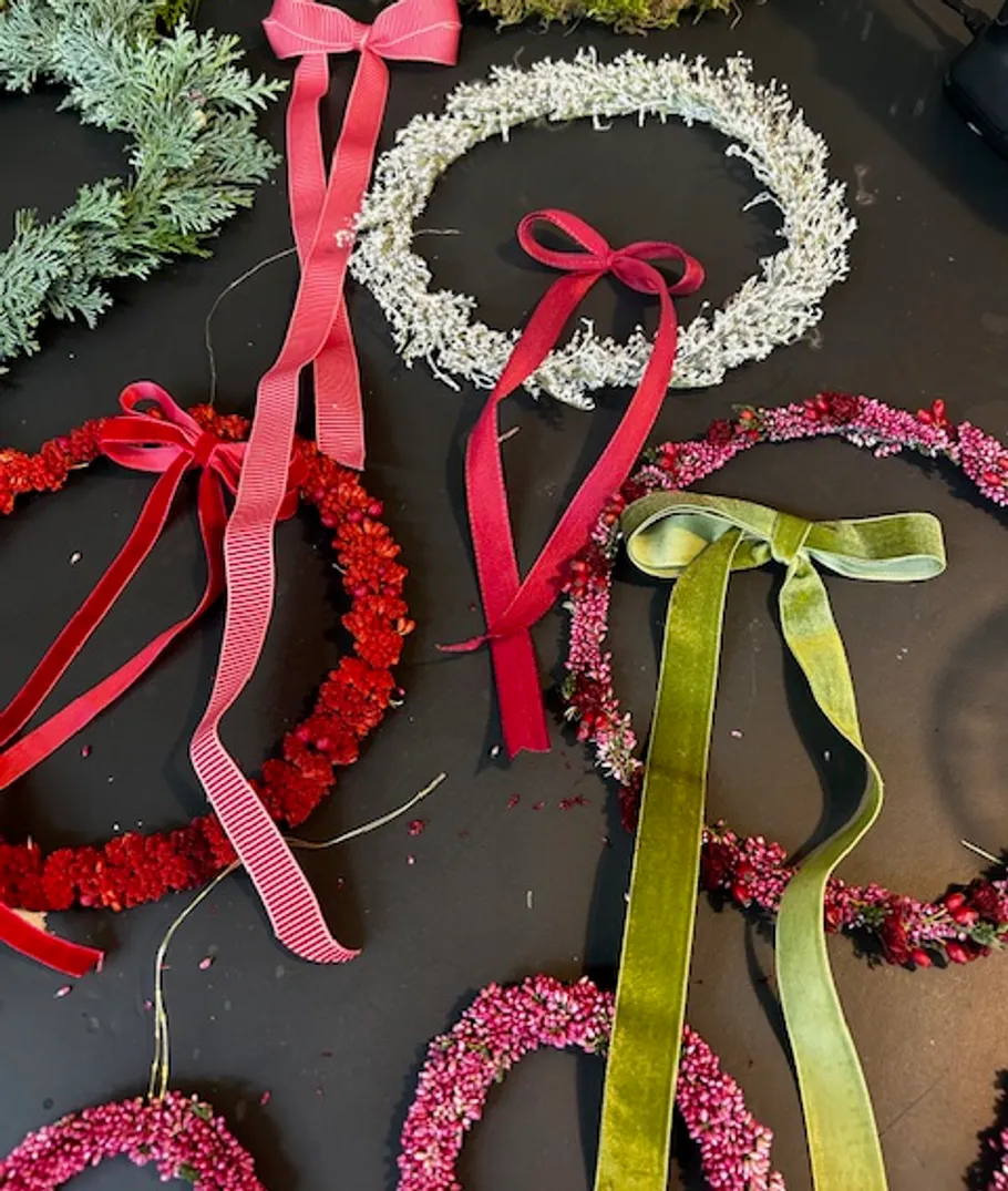 Decorative wreaths with colorful bows on table.
