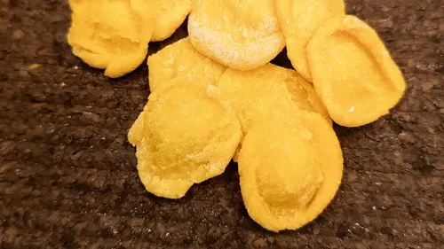 Orecchiette pasta on wooden surface.