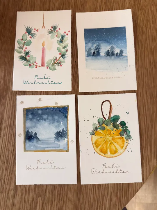 Four Christmas cards with festive illustrations.