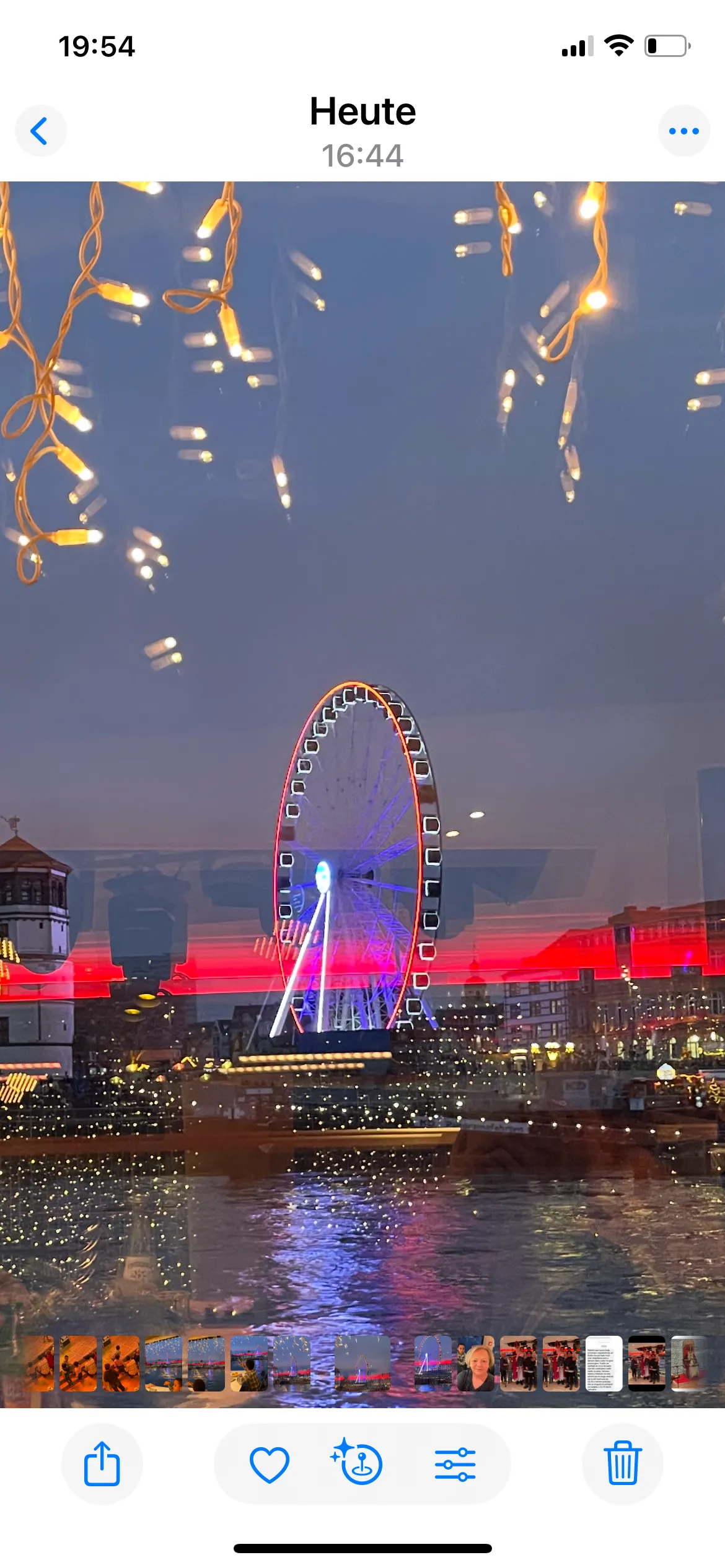 Riesenrad spiegelt sich mit Lichterketten.