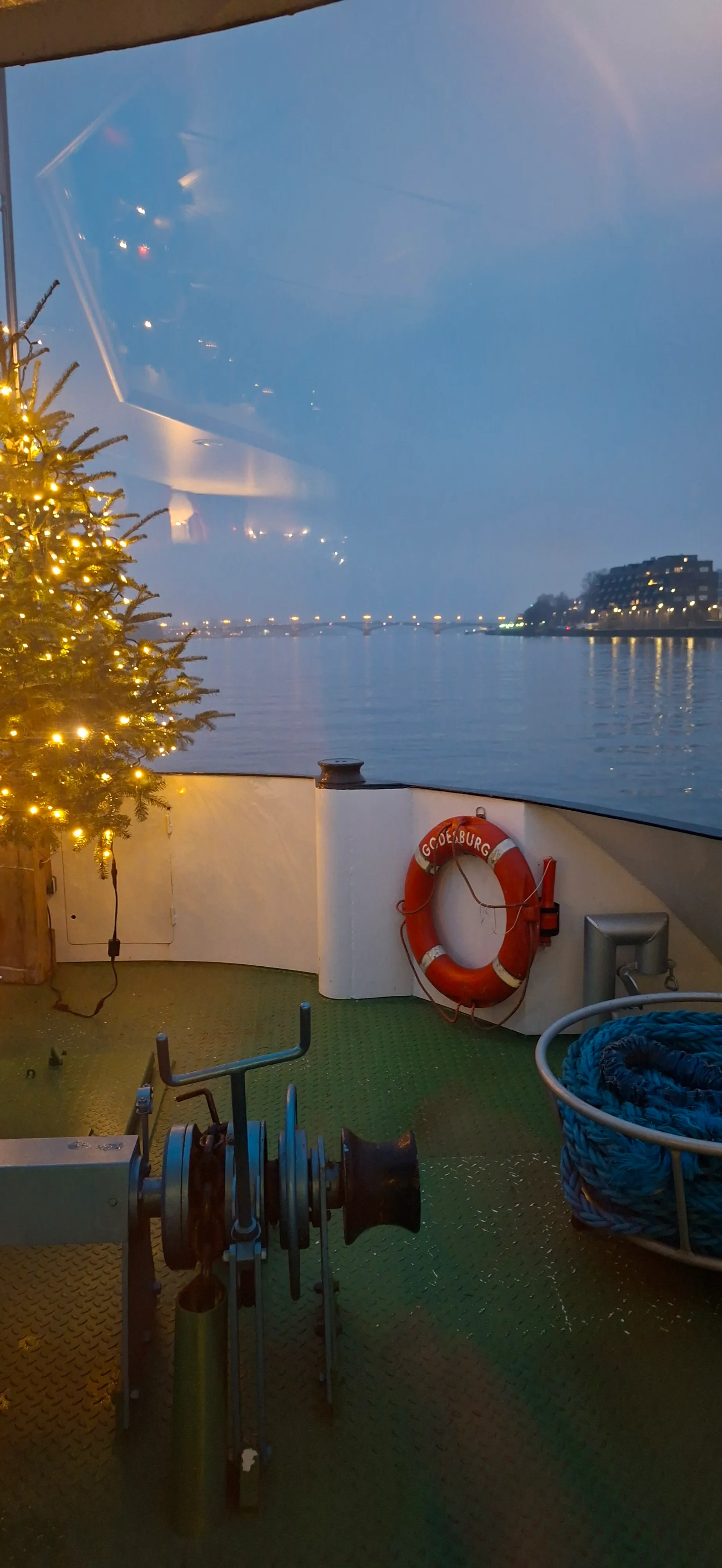 Weihnachtsbaum auf Bootsdeck am Abend.