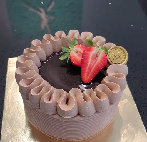 Schokoladenkuchen mit Erdbeeren oben drauf.