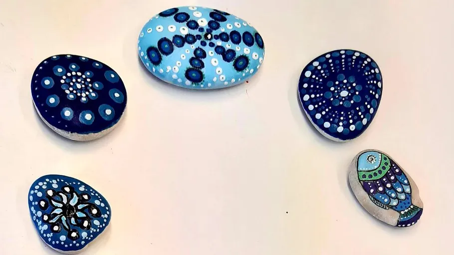 Painted stones with mandala and owl designs.
