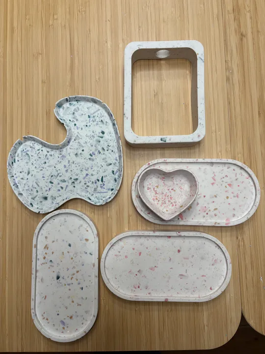 Bunte Terrazzo-Tabletts auf Holzoberfläche.