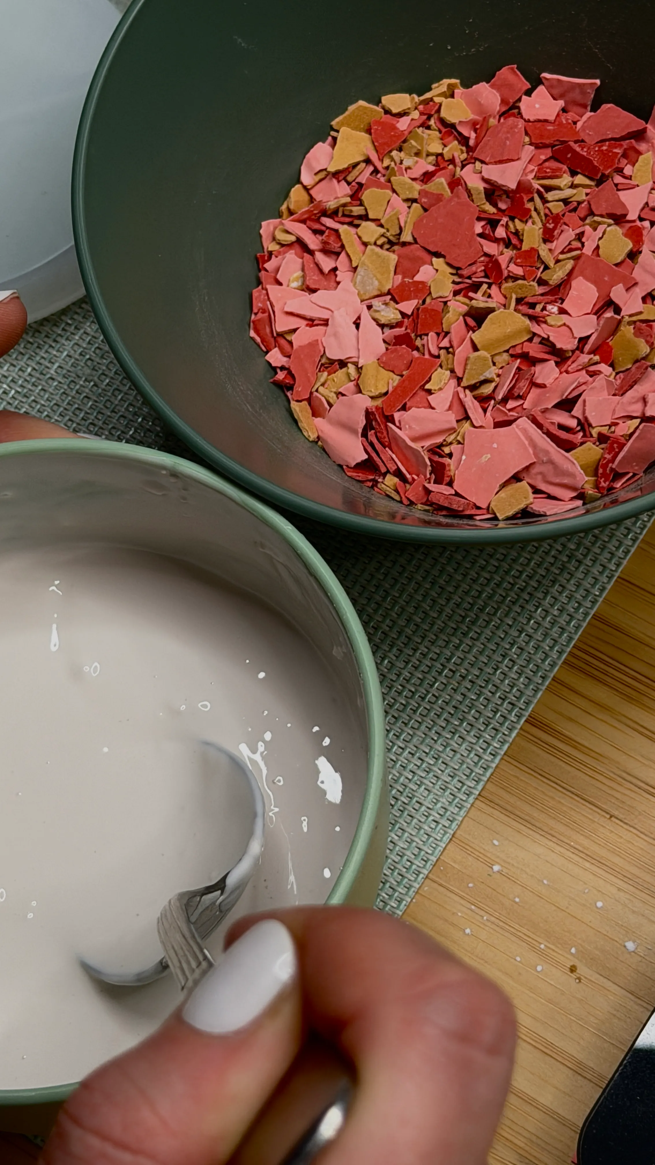 Bowl of pink chips and white mixture stirred.