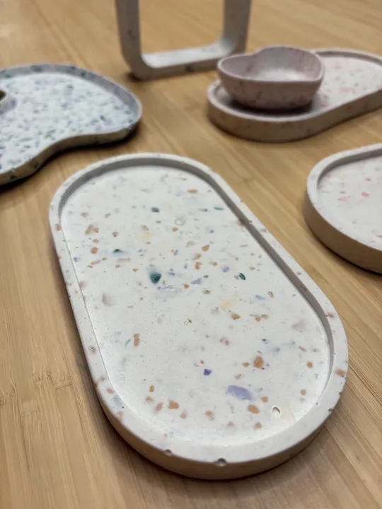 Bunte Terrazzo-Tabletts auf Holzoberfläche.