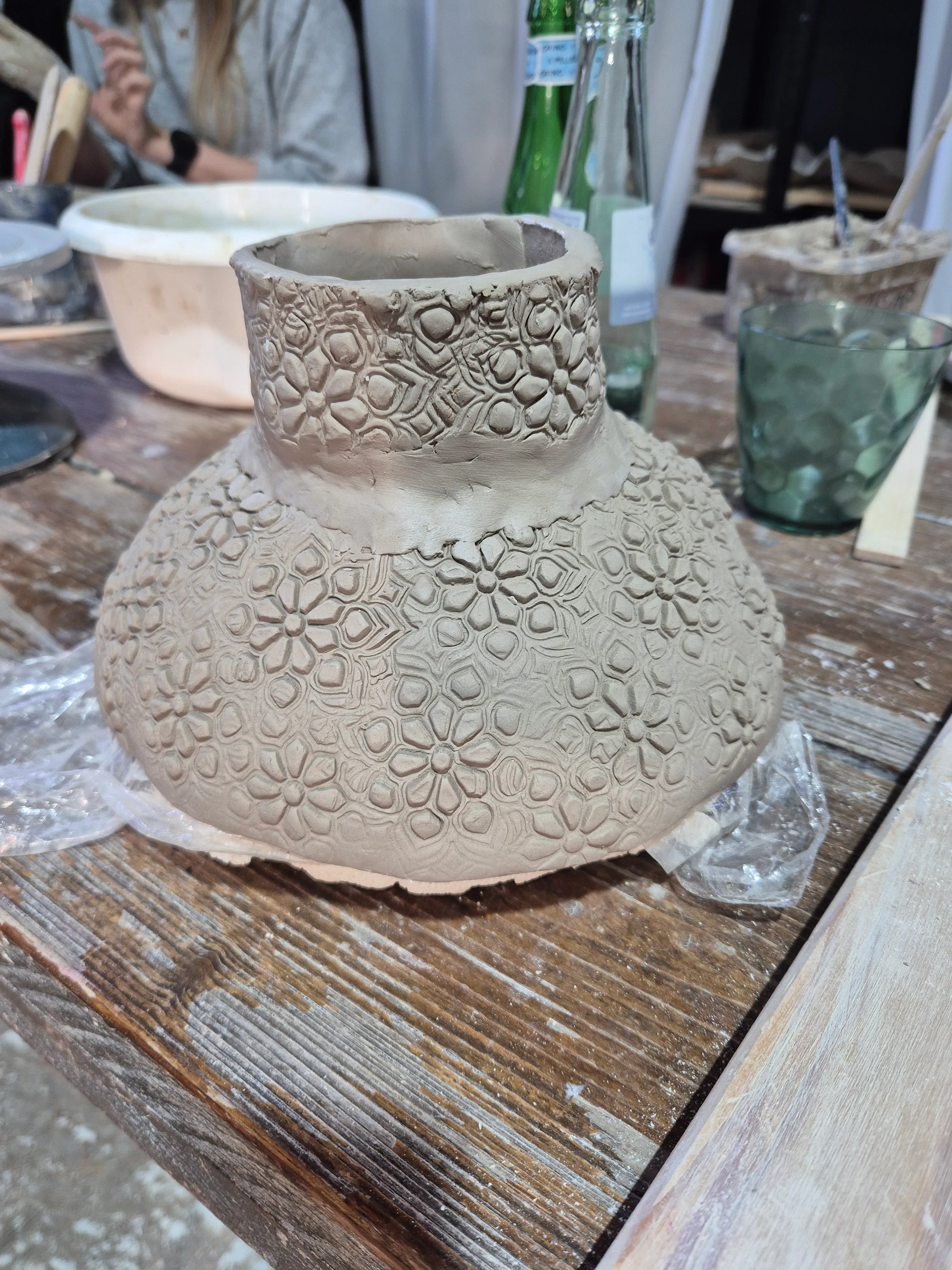 Textured pottery on wooden table in workshop.
