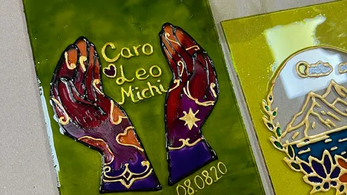 Colorful painted hands on green background.