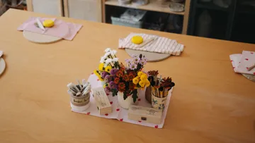 Blumen in Vase auf einem Esstisch.
