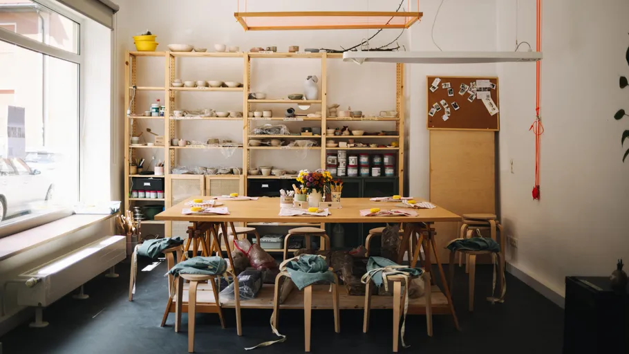 Cozy pottery studio with shelves and tables.